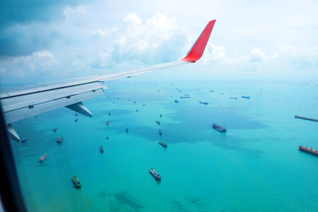 View from the plane on the wing sea and baot,Singaporeの写真素材