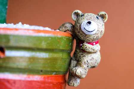 Closed up image of Ceramic bear  on Colorful cacus pot with orange brick backgroundの写真素材