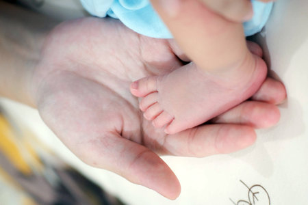 Tiny Newborn Baby 's Foot On Female Hands , Closeup.の写真素材