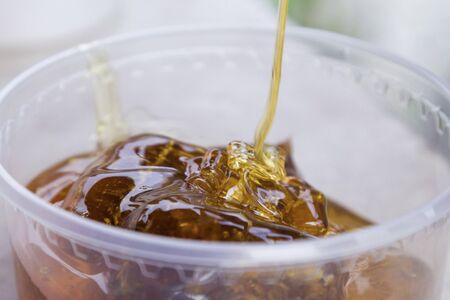 Honey is poured into a jar