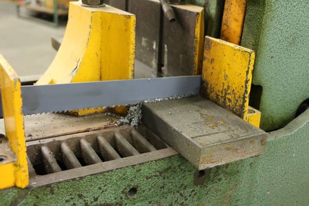 Electric bow saws sawing off a steel blockの写真素材