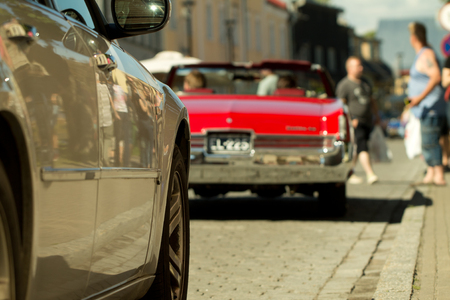 HAAPSALU, ESTONIA - JULY 16, 2016. Old retro red car back and side of the new car with people inside on American Beauty Car Show 2016.のeditorial素材