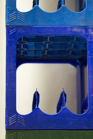 Green and blue Plastic bottle Crates stacked in piles at the liquour store stock.の写真素材