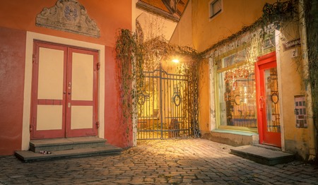 Tallinn, Estonia - November 21st 2016: Street near town hall in Tallinn Estonia, at night. Lovely ancient view with gates and warm lights. Rustic architecture cityscapes landmarks old town patioのeditorial素材