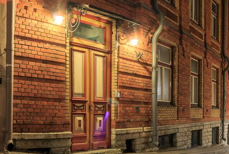 Lovely ancient view for street going down. Rustic architecture cityscapes landmarks old town brick red wall and door in it. Lights at night or evening.の写真素材