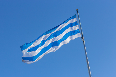 Waving Flag of Tallinn, Estonia, Blue and White stripes isolated on blue sky background.の写真素材