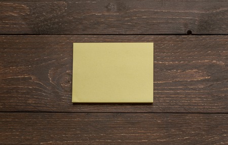 Yellow pack pile of stickers on the dark wooden antique background for advertising mockup templateの写真素材