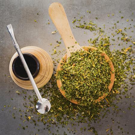 Traditional Yerba Mate tea with matero and bombilla, healthy, energy boosting drink on neutral stone...