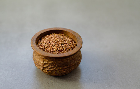 Buckwheat in a wooden bowl ongray stone backgroundの写真素材