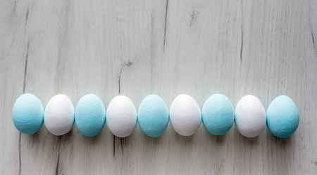 Spring and Easter holiday concept. Easter eggs painted blue and white, pastel color background....