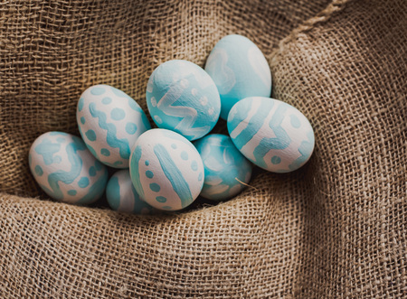 Hand painted eggs on brown cloth background.