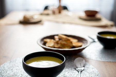 Green broccoli & spinach vegetable soup in black plate on wooden table.の写真素材