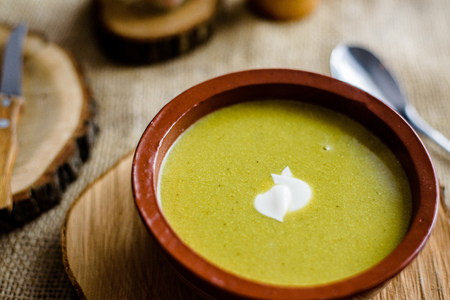 Green organic broccoli soup in ceramic bowl. Wooden plate with delicious croutons bread. Vegan, organic diet dish.の写真素材