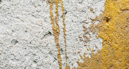 Grungy wall background with cracks, stones and paint.