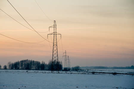 Hi-voltage electric power lines in a wintry foggy landscape.の写真素材
