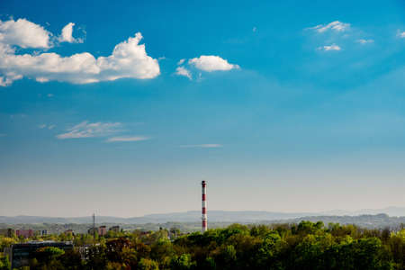 Chimney over green suburban areas. Ecology, pollution concept of smoke, carbon dioxide and oxygen.