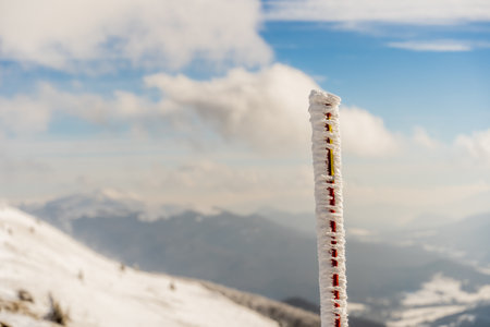 Hiking poles covered with ice against the background of snowy mountains.の写真素材