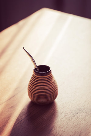 A wooden container with a metal straw on a wooden table. Selective focus.の写真素材