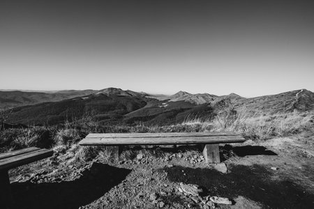 Wooden bench on the top of a mountain in black and whiteの写真素材