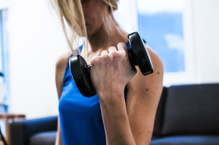 girl making fitness exercises, stretching, weight lifting and abdominalsの写真素材