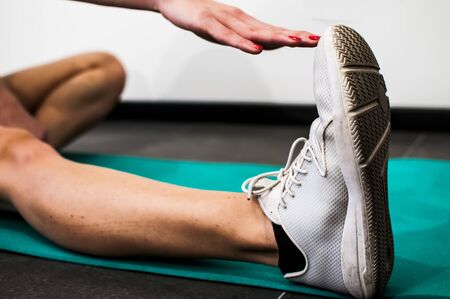 girl making fitness exercises, stretching, weight lifting and abdominalsの写真素材