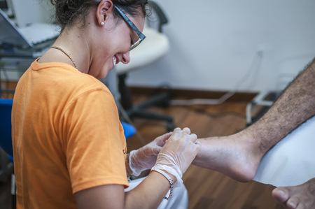 podiatry doctor curing a young patient feetの写真素材