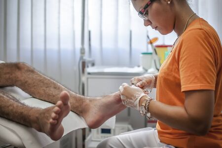 podiatry doctor curing a young patient feetの写真素材