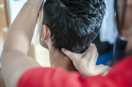 physiotherapist massages young patient to cure a cervical painの写真素材