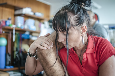 physiotherapist visits a young sportsman who feels pain at legの写真素材