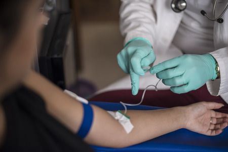 A nurse takes blood samples for medical examination
