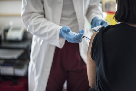 Doctor performs vaccination on young girl