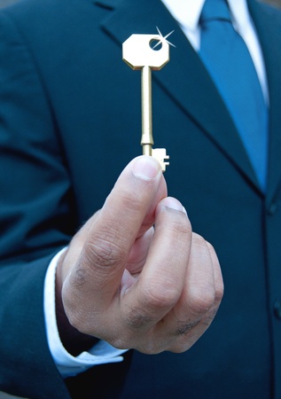 Businessman with shiny gold key の写真素材