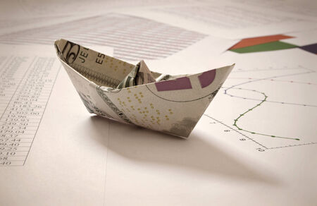 Paper boat over financial dataの写真素材