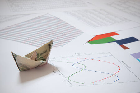 Dollar paper boat on financial data の写真素材