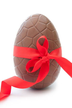Chocolate easter egg with decorative red ribbon の写真素材