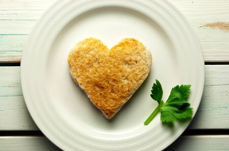 Heart shape toast on a plate with celery leafの写真素材