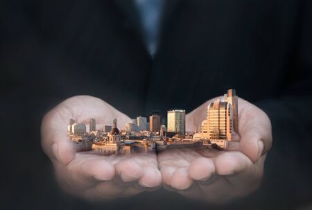 Business man holding city skyline skyscrapers and buildingsの写真素材