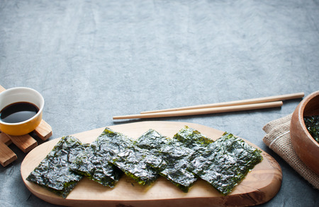 Seaweed wafer snacks on a serving block with copy space
