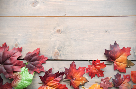 Autumn leaves on top of a wooden background with spaceの写真素材