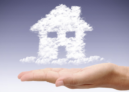 House made from clouds hovering over a handの写真素材