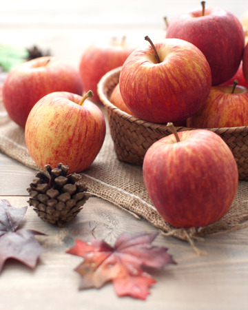 Autumn leaves with apples over a wooden backgroundの写真素材