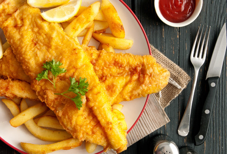 Close up of battered fish on a plate with chipsの写真素材