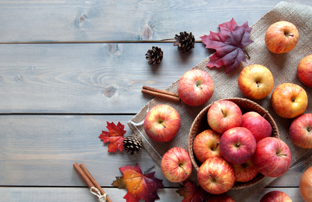 Autumn leaves, apples over a wooden background with spaceの写真素材