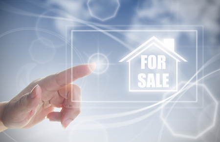 Finger pressing touch screen interface with house real estate for sale signの写真素材