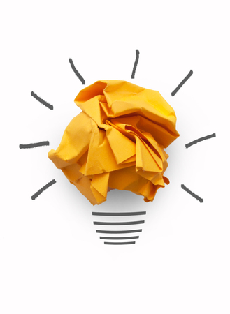 Orange paper light bulb over a white backgroundの写真素材