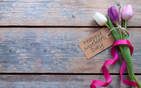 Mothers day label attached to spring tulips with decorative ribbonの写真素材