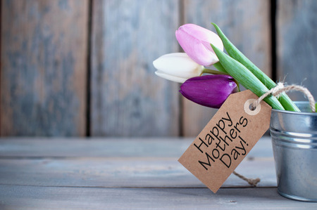 Mothers day tulips in a pot wooden background with space with gift labelの写真素材