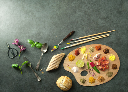 Fresh cooking ingredients including herb and spices on a painters palette with spaceの写真素材