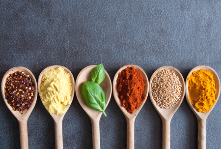 Herbs and spices in wooden spoons border with spaceの写真素材