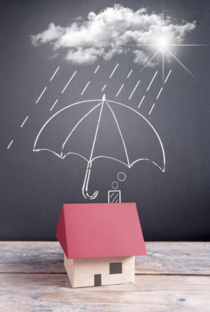 Umbrella sketch on a chalkboard protecting a houseの写真素材
